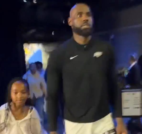 詹姆斯牵着女儿的手走出球馆，微笑着指向她：我的幸运星就在这